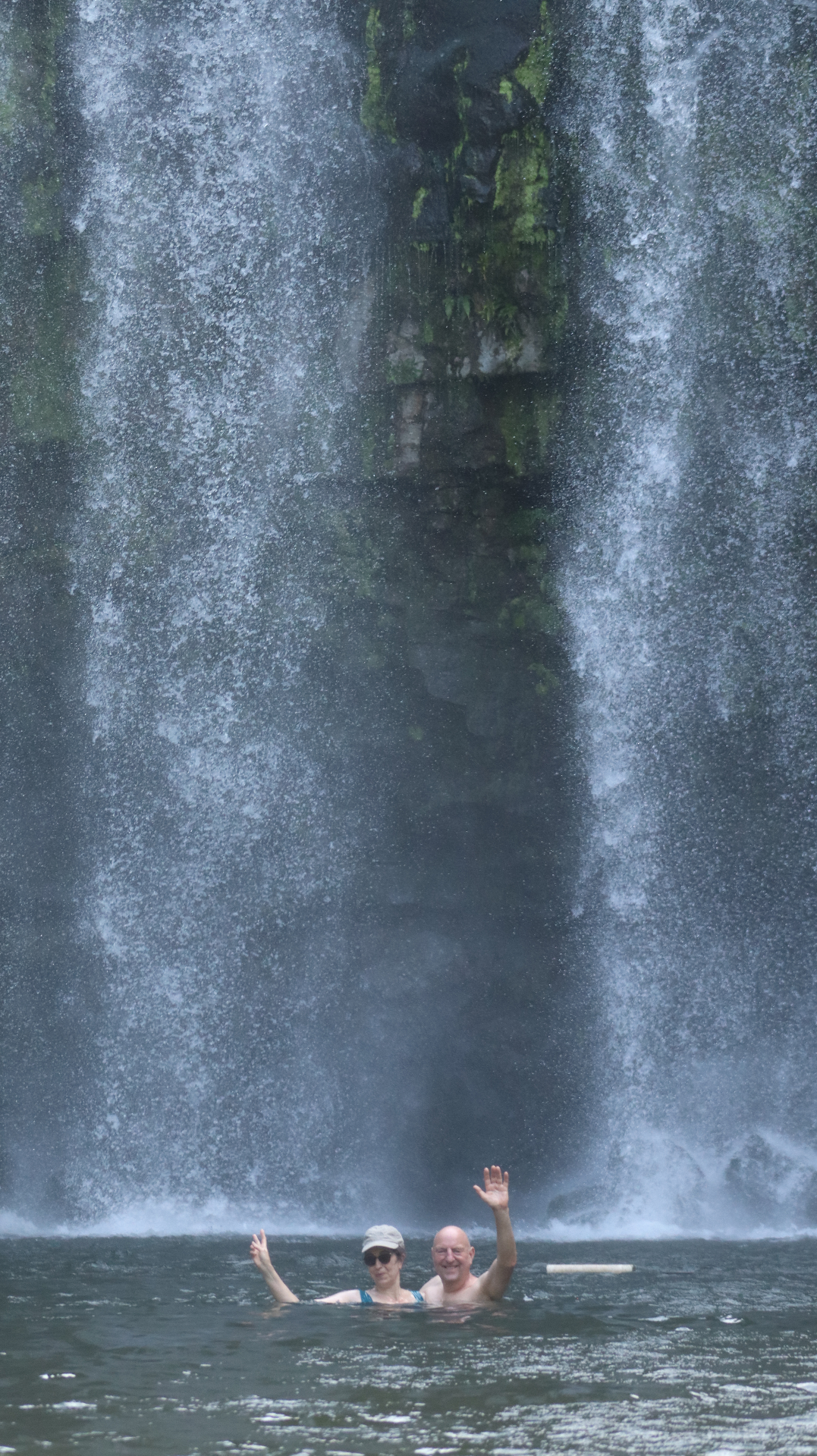Guests swimming behind the Llanos de Cortés waterfall